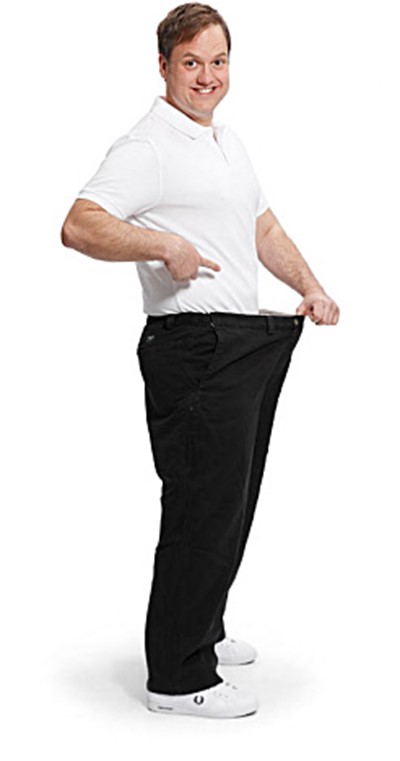 Image of Johan holding his pants showing weight-loss. Photo 