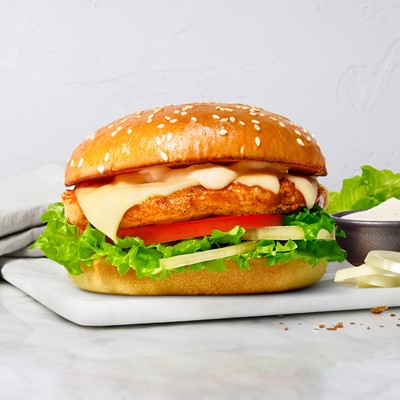 Hamburger with chicken and a sallad on the side.  Photo.